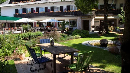 Landhotel Rosentaler Hof © Landhotel Rosentaler Hof Gartenterrasse mit Tisch, Stühlen und Springbrunnen vor einem Hotel