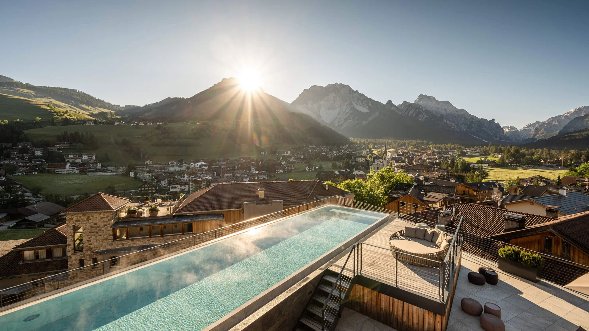 Gravelbike Holidays © Lorenz Masser Sonnenaufgang über einem Bergdorf mit beheiztem Pool auf einer Terrasse