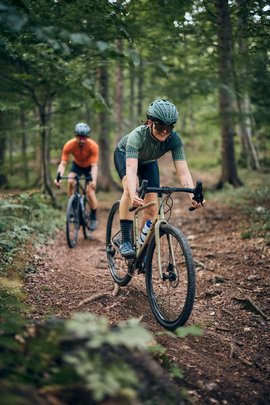 Gravelbike Holidays © Tobias Köhler Zwei Radfahrer fahren auf einem Waldweg Mountainbike
