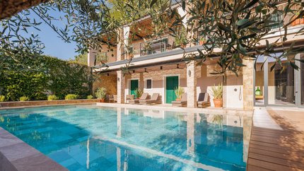 Hotel Vila Robida © Jaka Ivancic Haus mit Swimmingpool und Garten unter blauem Himmel