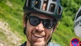 Gravelbike Holidays © Alain Rumpf - A Swiss With A Pulse Zwei Radfahrer mit Helmen unterhalten sich an einer Bergstraße