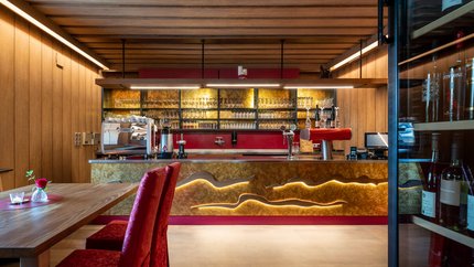 Hotel zur Post © Gert Perauer Moderner Barbereich mit Holzvertäfelung und roten Sitzstühlen