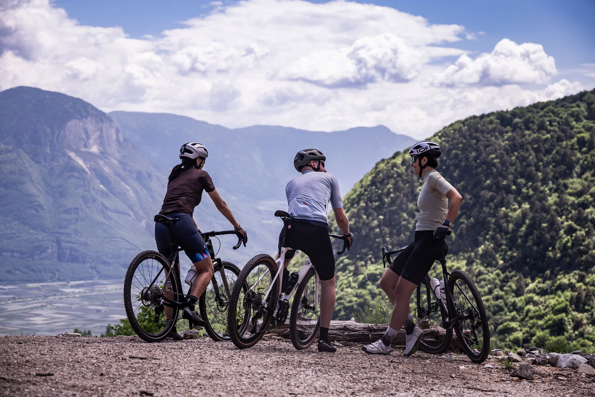 Gravelbike Holidays © Heiko Mandl Drei Radfahrer genießen die Aussicht in den Bergen bei klarem Himmel