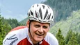 Gravelbike Holidays © GA SERVICE Mann fährt Rennrad auf Bergstraße mit Nadelbäumen im Hintergrund