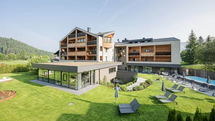 Hotel Laurin's © Harald Wisthaler Modernes Hotel mit Garten, Pool und Sonnenliegen in sonniger Landschaft